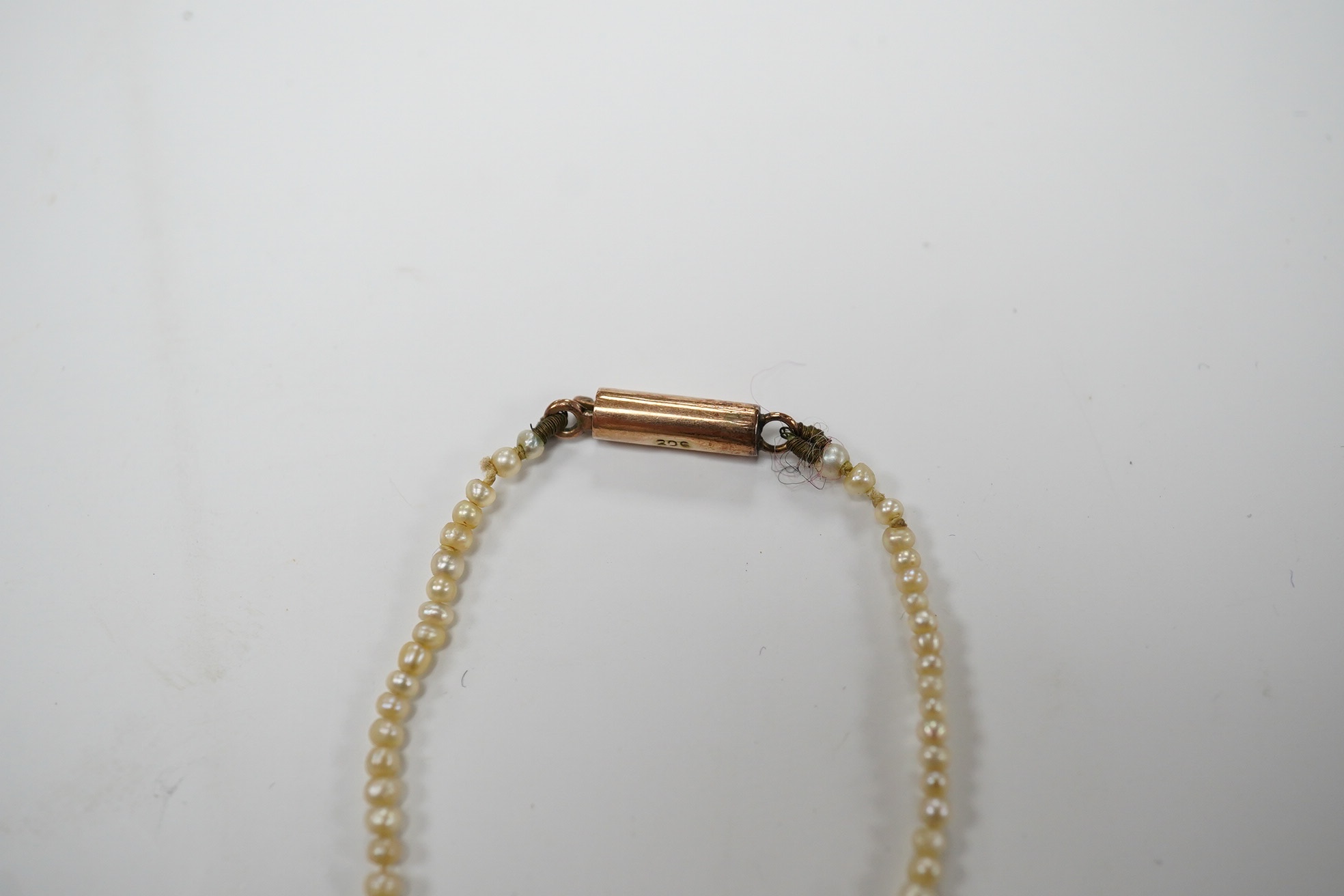 An early 20th century single strand graduated seed pearl necklace, with 9ct barrel clasp, 38cm. Condition - fair